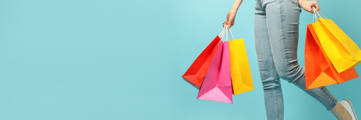 Beautiful young woman and shopping bags on blue background
